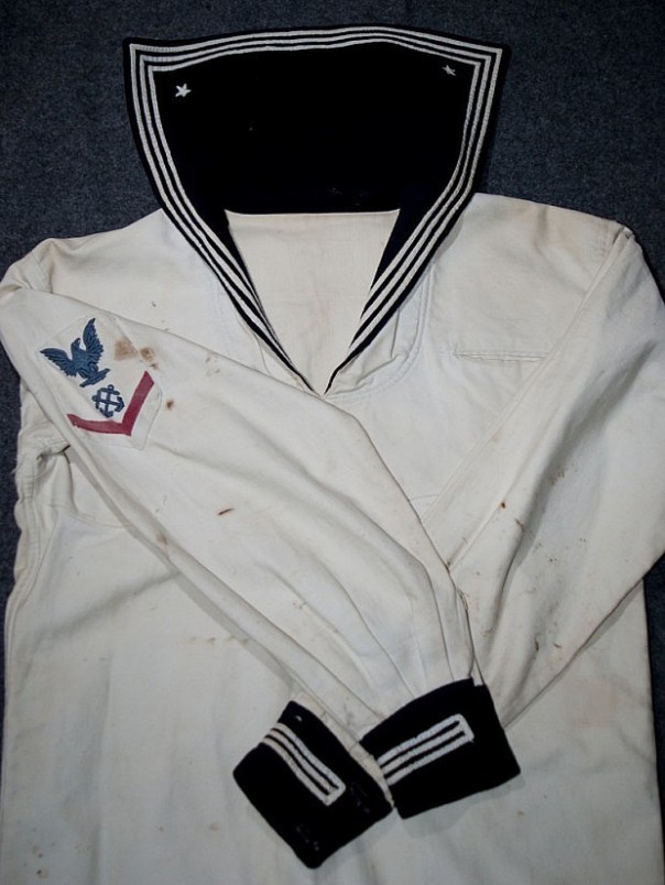 I have the privilege of owning this 1905-1913 coxswain dress white uniform. Note the blue wool cuffs and collar flap and the three-stripe white piping affixed. The flap also has two white stars directly embroidered to each corner.