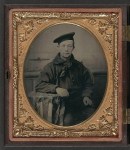 This Civil War-vintage tin type photograph shows a sailor wearing his dress blue jumper, blue neckerchief, and flat hat (source: Library of Congress).