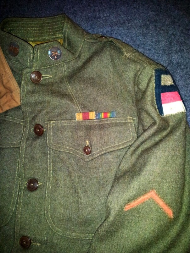 A close up of the SSI of the 1st Army (with the red and white bars of the artillery), my uncle's collar disks, the honorable discharge chevron and his actual ribbons.
