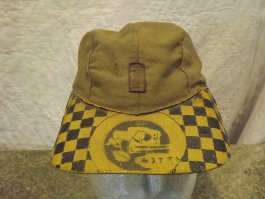 This khaki aviator’s ball cap is an oddity with this artwork on the bill. A sewn-on rank insignia adorns the front panel (source: eBay Image).