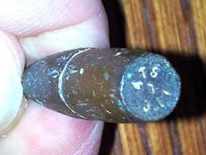 They are difficult to make out with the naked eye, but the markings are “A-T-S” and “L-V-C”. The character in the center doesn’t appear to be a character at all.